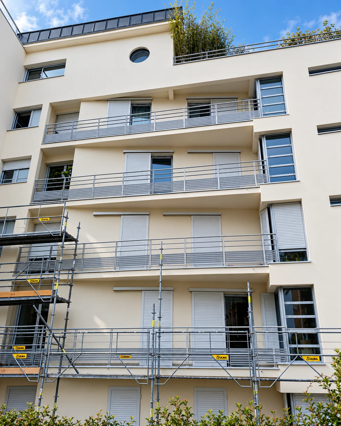 Façade d'immeuble rénovée avec balcons repeints et enduits extérieurs lisses