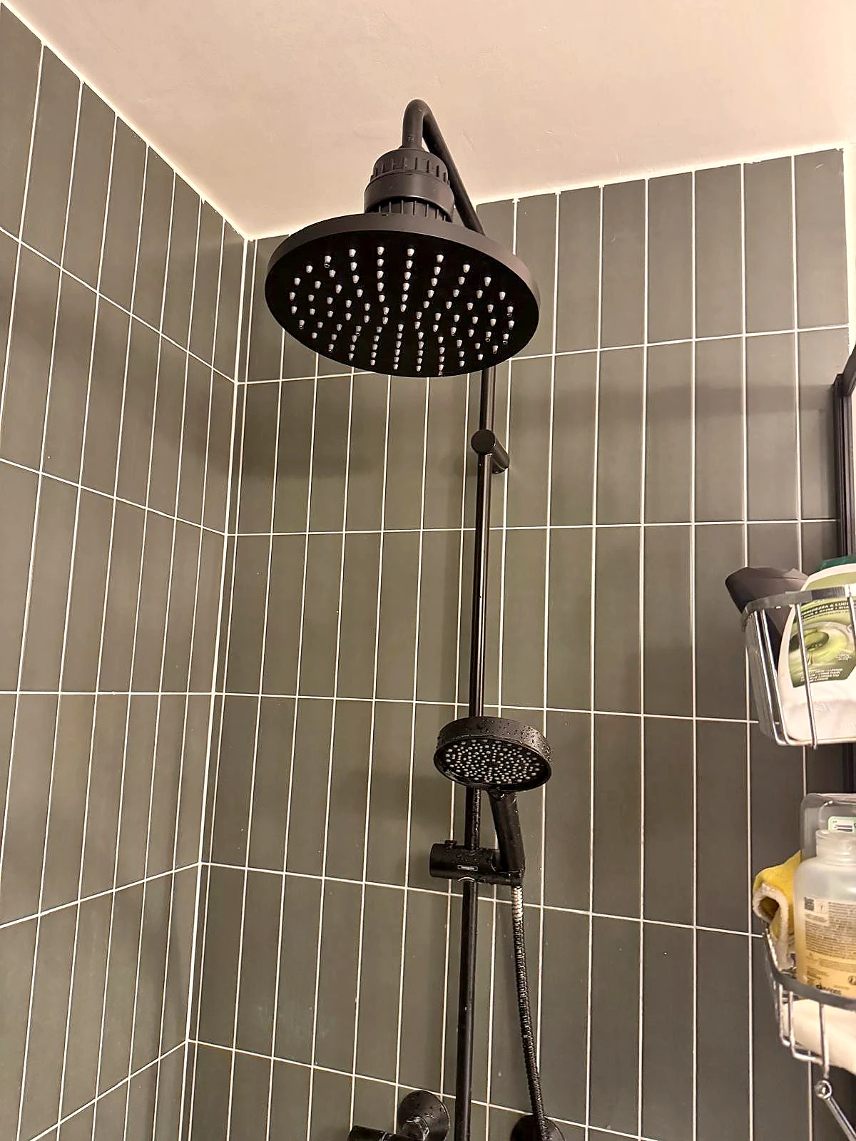 Colonne de douche mitigeur noir mat sur carrelage mural gris contemporain